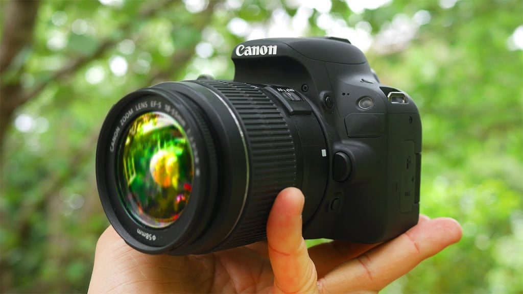 photo of a dslr camera being held in one hand